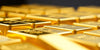 Close-up of gleaming gold bars reflecting light.